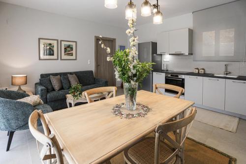 a kitchen and living room with a wooden dining room table at Kotrona Apartments in Kalavrita