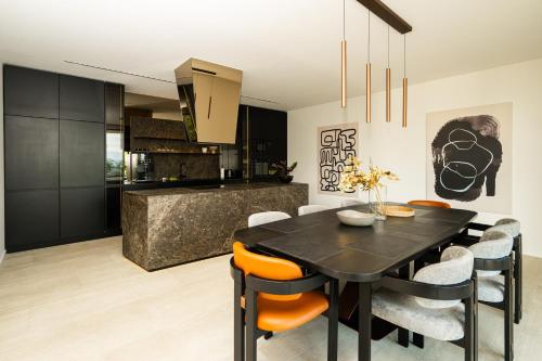 a kitchen and dining room with a black table and chairs at The Villa O in Sarajevo