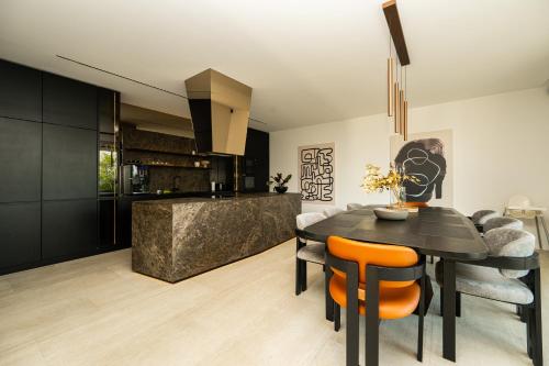 a kitchen and dining room with a black table and chairs at The Villa O in Sarajevo