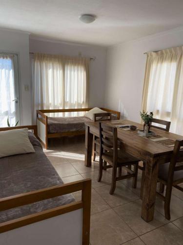 a living room with a bed and a table and chairs at Complejo Pampa 1 in Santa Rosa