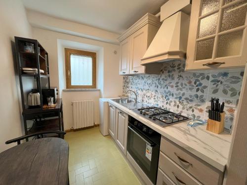 a kitchen with white cabinets and a stove top oven at Inti in Lucca