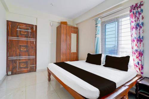 a bedroom with a bed and a large window at Paradise Living in Bangalore