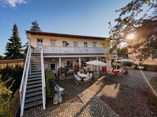 a house with a staircase leading up to a patio at Pension Adele - Ruhig, direkt am Elberadweg & Badesee mit Balkon in Dresden