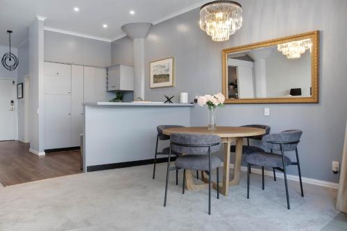 a dining room with a table and chairs and a mirror at Spacious Newly Renovated Princes Wharf 1BR in Auckland
