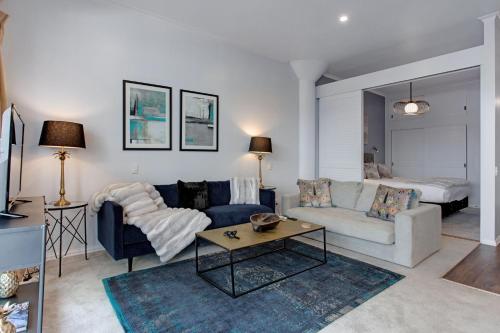 a living room with a couch and a table at Spacious Newly Renovated Princes Wharf 1BR in Auckland