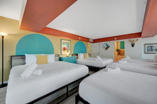 two beds in a room with blue and orange ceilings at Stay Together Suites - Stunning Penthouse On The Strip Sleeps 16 - NO RESORT FEE in Las Vegas