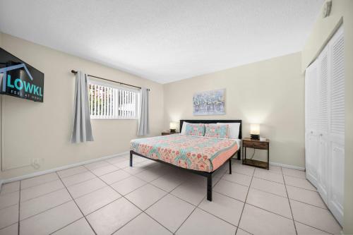 a bedroom with a bed and a window at Coco Palms Apartments By Lowkl in Lighthouse Point