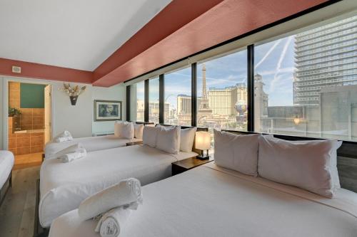 a hotel room with two beds and a large window at Stay Together Suites - Stunning Penthouse On The Strip Sleeps 16 - NO RESORT FEE in Las Vegas