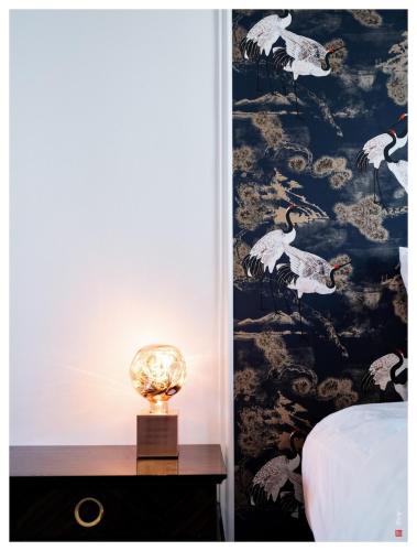 une lampe sur une table de nuit à côté d'un lit dans l'établissement Terrasse 4P - 16 min Paris - Bois de Vincennes 700m, à Charenton-le-Pont