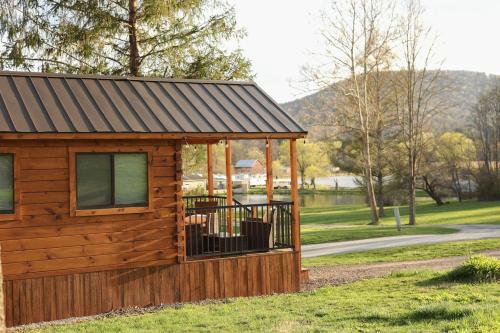 a small wooden cabin with a metal roof at Route 6 Campground in Gaines