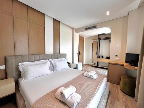 a hotel room with a bed with towels on it at Avenue Hotel in Ksamil