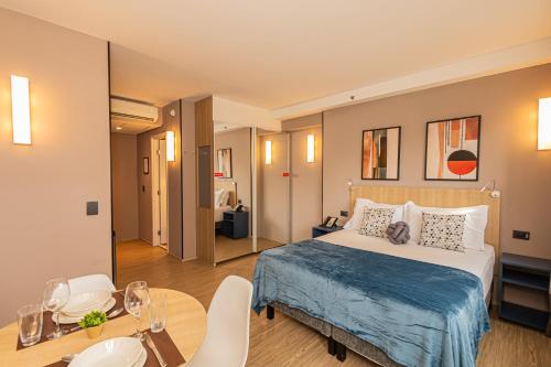 a hotel room with a bed and a table and chairs at APS - Alpha Stay By Anora Spaces in Barueri