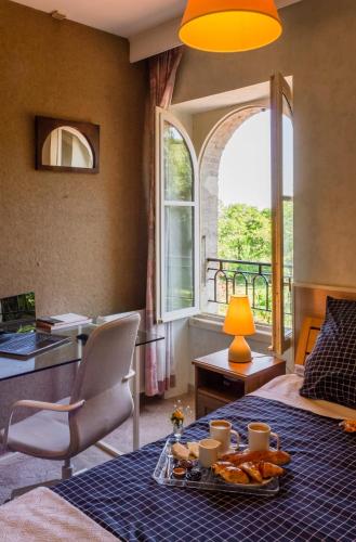 a room with a bed and a table with a tray of food at Lacoume Saint Jacques in Auch