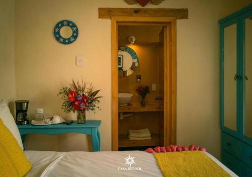 a bedroom with a bed and a bathroom with a sink at Hotel Casa del Sol in San Cristóbal de Las Casas