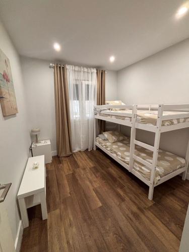 a room with two bunk beds and a table at La caprichosa in Chiclana de la Frontera