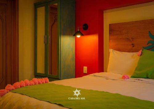 a bedroom with a bed with a green and red wall at Hotel Casa del Sol in San Cristóbal de Las Casas