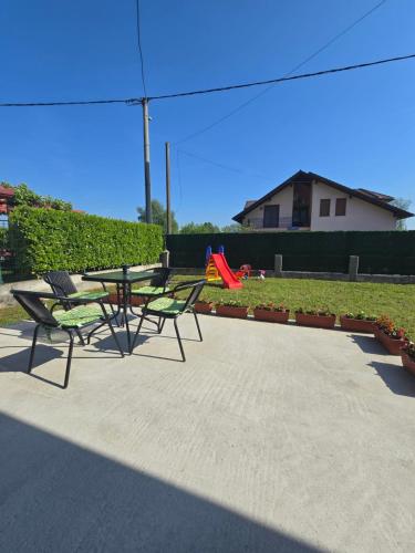 a picnic table and chairs in a park with a playground at Apartman Nia in Bihać
