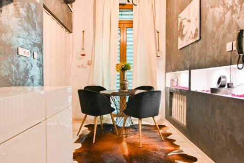 a dining room with a table and black chairs at Luxory in Sofia