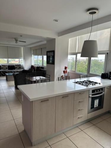 a kitchen with a white counter top and a living room at Departamentos de Lujo Alameda in Mexico City