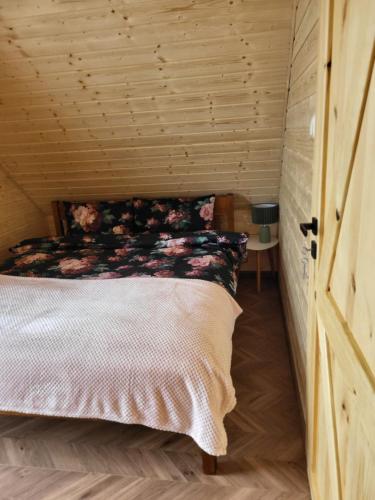 a bedroom with a bed in a wooden room at Noclegi Bieszczady, Domki na Bani in Łukowe