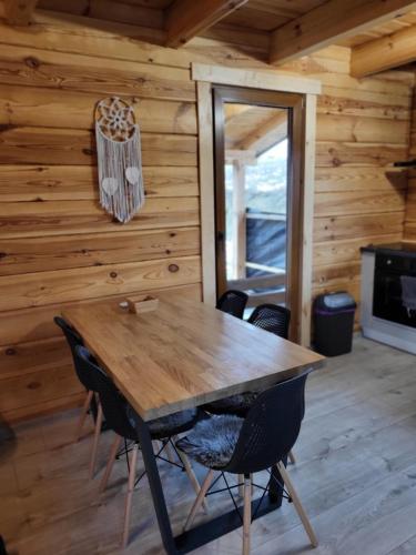 a dining room with a wooden table and chairs at Noclegi Bieszczady, Domki na Bani in Łukowe