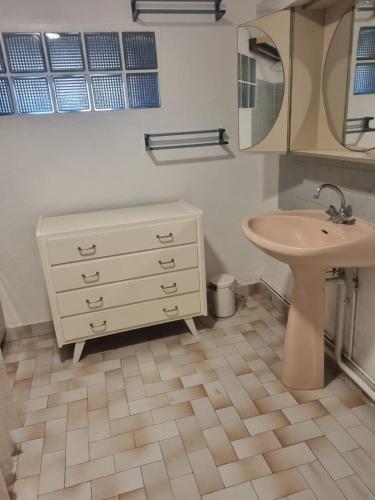 La salle de bains est pourvue d'un lavabo et d'une commode blanche. dans l'établissement Gîte dans Parc Naturel Proche Forêt & Spa - Parking Inclus, à Saint-Honoré-les-Bains