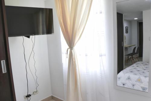 a bedroom with a bed and a window with curtains at Confort y estilo apartaestudio 301 cerca Av de los estudiantes in Pasto