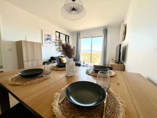 une table de salle à manger avec des assiettes noires dessus dans l'établissement 2P sea view, very central, à Saint-Laurent-du-Var