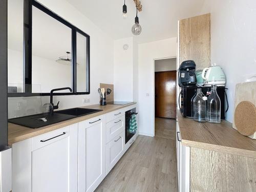 La cuisine est équipée de placards blancs, d'un lavabo et d'un miroir. dans l'établissement 2P sea view, very central, à Saint-Laurent-du-Var