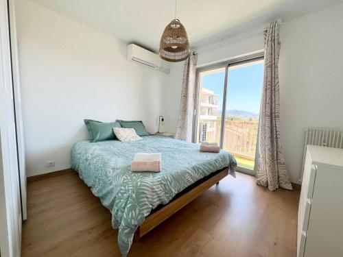une chambre avec un lit et une grande fenêtre dans l'établissement 2P sea view, very central, à Saint-Laurent-du-Var