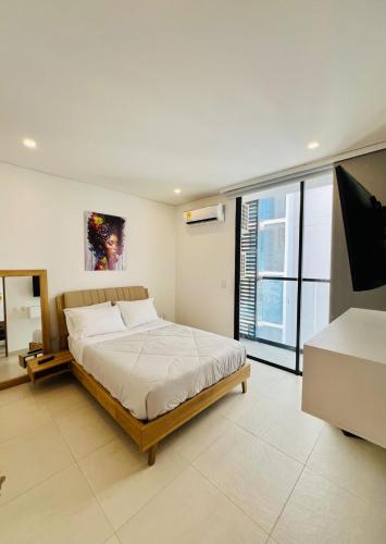 a bedroom with a bed and a flat screen tv at Comfortable apartment near the beach in Playa Bello Horizonte