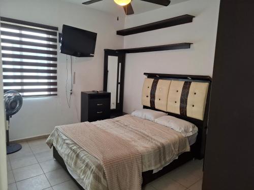 a bedroom with a bed and a flat screen tv at La casa del ejecutivo in Las Adjuntas