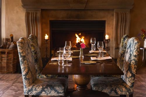 a wooden table with wine glasses and a fireplace at Mt Cook Lakeside Retreat in Lake Pukaki