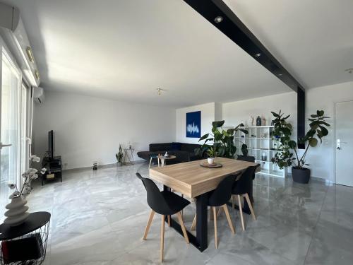 un salon avec une table et des chaises en bois dans l'établissement Montpellier Un écrin de lumière pour enchanter votre séjour, à Montpellier