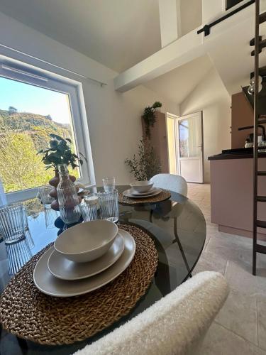 une salle à manger avec une table en verre et une grande fenêtre dans l'établissement Mon duplex, à Cherbourg en Cotentin