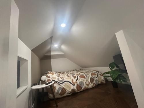 Cette petite chambre comprend un lit dans l'angle d'une pièce. dans l'établissement Mon duplex, à Cherbourg en Cotentin