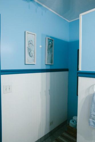 a bathroom with blue walls and a toilet in it at Las Tres Banderas Beach House in San Miguel