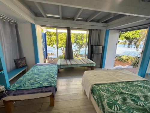 Postel nebo postele na pokoji v ubytování bungalow vue lagon 180 degré, la maison bleue