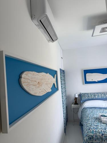 a bedroom with a picture of a fish on the wall at Appartamento Rapallo Sky Garden Maria Jose Liguria - Attico vista mare - Terraces - 2 bagni- 2 Camera da Letto - Box, Wi-fi, Idromassaggio Free inteiro Attico per Voi, con Ascensore in Rapallo