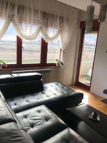 a living room with a couch and a large window at Sunny Luxury Apartment 2BDR in Bitola