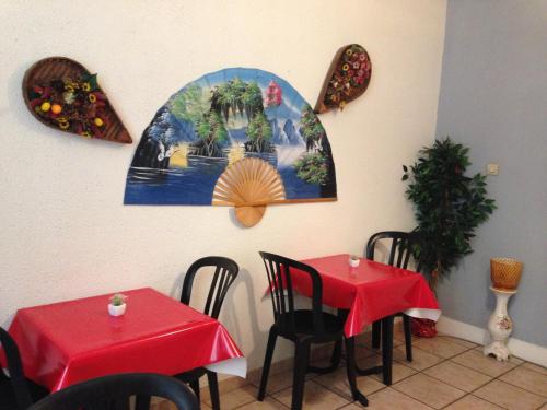 un restaurante con dos mesas con manteles rojos en Hotel Du Parc, en Burdeos