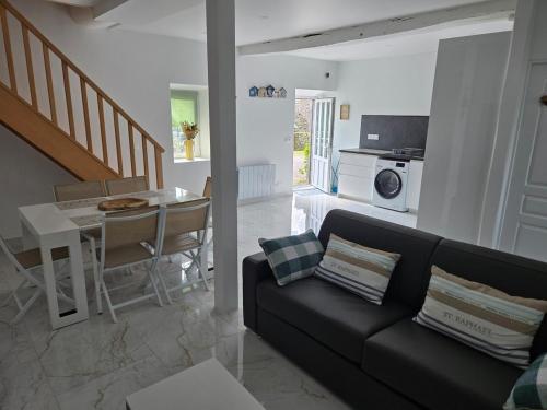 un salon avec un canapé noir et une table dans l'établissement maison à frehel, à Fréhel