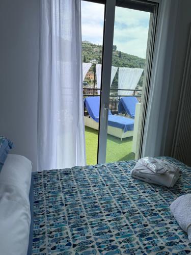 a bedroom with a bed and a view of a balcony at Appartamento Rapallo Sky Garden Maria Jose Liguria - Attico vista mare - Terraces - 2 bagni- 2 Camera da Letto - Box, Wi-fi, Idromassaggio Free inteiro Attico per Voi, con Ascensore in Rapallo