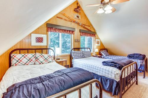 two beds in a room with wooden walls at 1 Mi to Lake Easton Cozy Cascades Cabin! in Cabin Creek