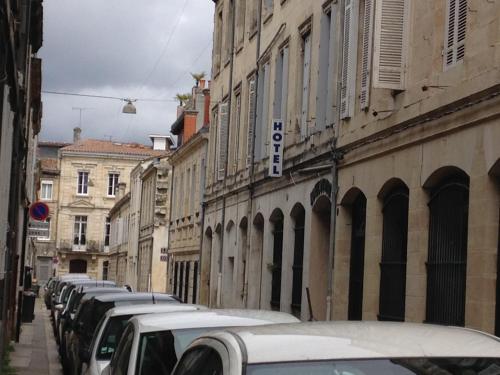 uma fila de carros estacionados numa rua com edifícios em Hotel Du Parc em Bordéus