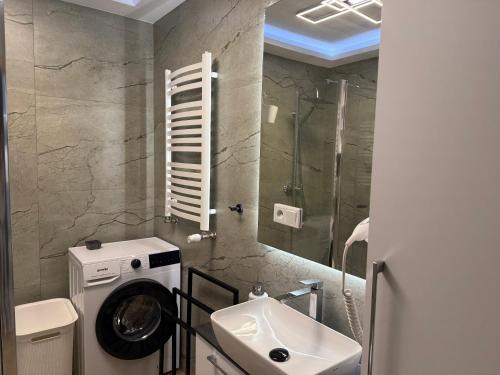 a bathroom with a washing machine and a sink at Apartament Księżycowy z garażem in Nowy Sącz