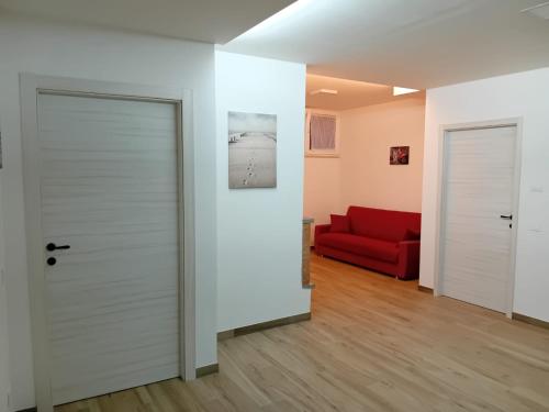 a room with a door and a red couch at Da Piero e Gina in Palidoro