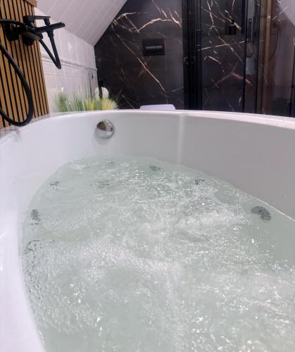 a bath tub filled with water in a bathroom at Domek za rzeką in Zawoja