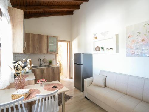 a kitchen and living room with a couch and a table at The Garden House in Antimácheia
