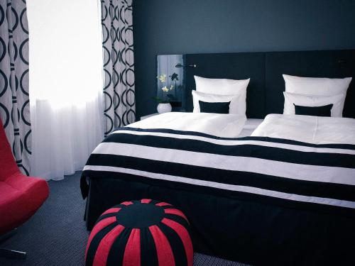 a bedroom with a large bed with black and white stripes at Vienna House by Wyndham Andel's Berlin in Berlin